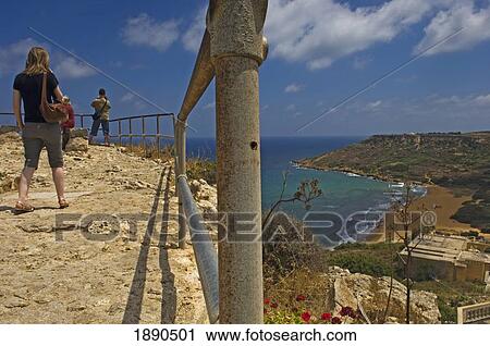 Stock Image - Tourists On Cliff Top At Calypso's Cave View Point. Fotosearch