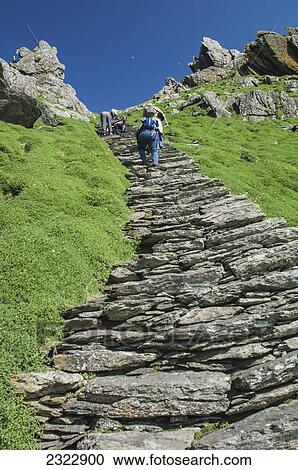 Stock Image - Tourists on footpath climbing up Skellig Michael; Skellig Islands, County Kerry, Ireland, UK. Fotosearch