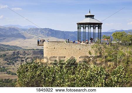 Stock Image - Tourists On Lookout Point Overlooking Serrania De Ronda; Ronda, Malaga Province, Spain. Fotosearch