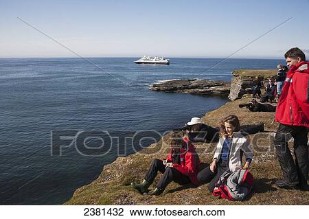 Tourists on shore with a cruise ship off the coast; Svalbard, Norway View Large Photo Image Stock Image - Tourists on shore with a cruise ship off the coast; Svalbard, Norway. Fotosearch