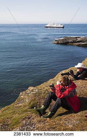 Tourists on shore with a cruise ship off the coast; Svalbard, Norway View Large Photo Image Stock Image - Tourists on shore with a cruise ship off the coast; Svalbard, Norway. Fotosearch