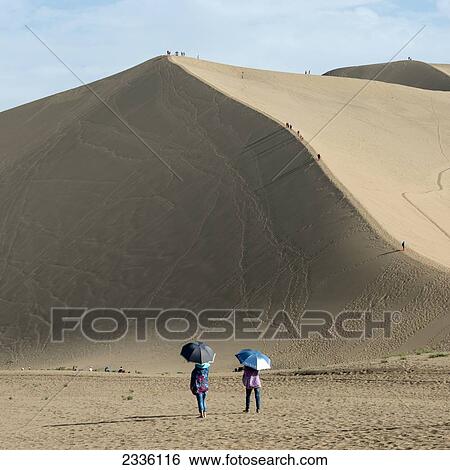 Stock Photograph - Tourists On Singing Sand Mountain; Jiuquan, Gansu, China. Fotosearch