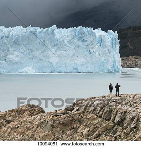 Stock Image - Tourists on the shore of Lake Argentino with a view of Moreno Glacier, Los Glaciares National Park; Santa Cruz province, Argentina. Fotosearch