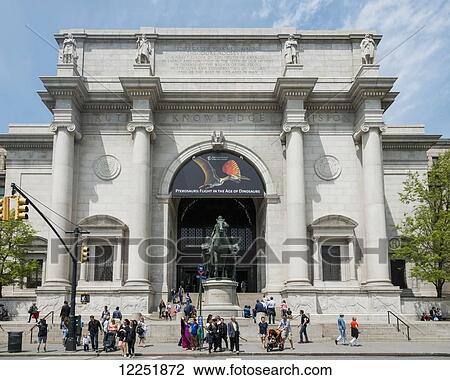 Stock Image - Tourists outside a building inscribed with the words truth, knowledge and wisdom; New York City, New York, United States of America. Fotosearch