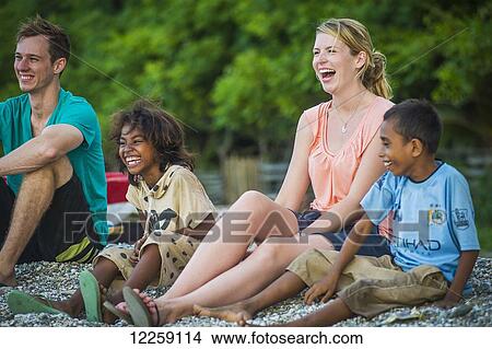 Picture - Tourists playing with children on Dili beach; Dili, Timor-Leste. Fotosearch