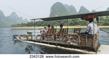 Tourists Riding A Boat Down Li River; Ynagshuo, Guangxi, China View Large Photo Image Stock Photo - Tourists Riding A Boat Down Li River; Ynagshuo, Guangxi, China. Fotosearch