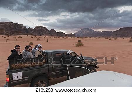 Stock Photo - Tourists Sitting In The Back Of A 4X4 Vehicle Before Being Transported To A Captain's Eco Desert Camp, Wadi Rum, Jordan, Middle East. Fotosearch
