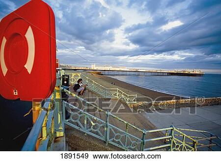 Stock Photo - Tourists Sitting On Brighton Pier. Fotosearch