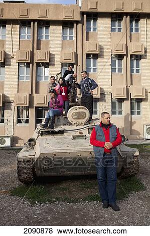 Stock Photo - Tourists Standing On Tank At The Amna Suraka (Red Security) Museum, Iraqi Kurdistan, Iraq. Fotosearch