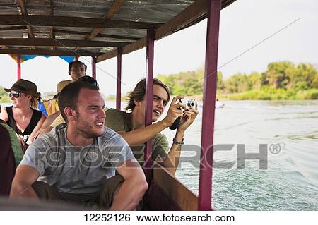 Stock Photograph - Tourists take a ferry on the Mekong River to the Island of Don Det; Laos. Fotosearch