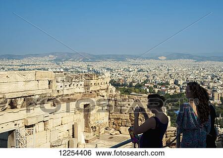 Stock Photograph - Tourists take pictures of ruins, view from the Acropolis; Athens, Greece. Fotosearch