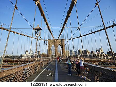 Tourists taking photographs on Brooklyn Bridge; New York City, New York, United States of America View Large Photo Image Stock Image - Tourists taking photographs on Brooklyn Bridge; New York City, New York, United States of America. Fotosearch