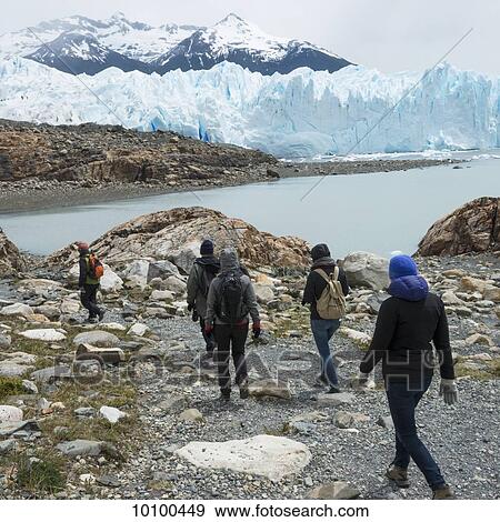Stock Photo - Tourists walk by Lake Argentino and Moreno Glacier, Los Glaciares National Park; Santa Cruz province, Argentina. Fotosearch