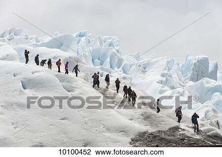Stock Image - Tourists walk on Moreno Glacier, Los Glaciares National Park; Santa Cruz province, Argentina. Fotosearch