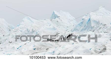 Stock Image - Tourists walk on Moreno Glacier, Los Glaciares National Park; Santa Cruz province, Argentina. Fotosearch