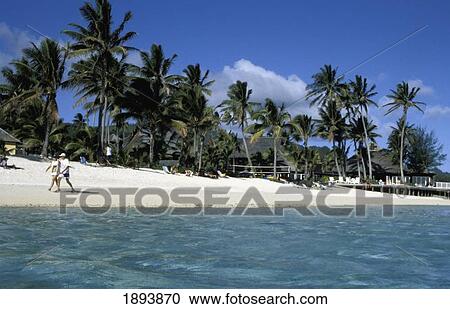Stock Image - Tourists Walking On Beach. Fotosearch