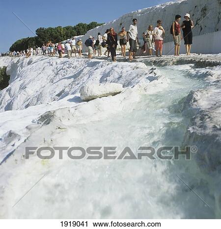 Stock Image - Tourists Walking On Pamukkale Calcium Formations. Fotosearch