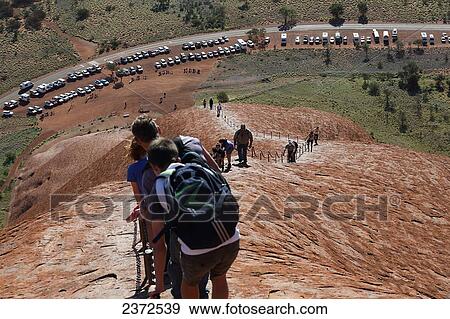 Tourists walking up Uluru, formerly known as Ayers Rock; Northern Territory, Australia View Large Photo Image Stock Photo - Tourists walking up Uluru, formerly known as Ayers Rock; Northern Territory, Australia. Fotosearch