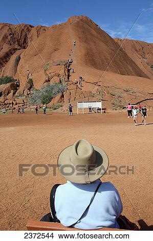 Tourists watching people climb Uluru, formerly known as Ayers Rock; Northern Territory, Australia View Large Photo Image Picture - Tourists watching people climb Uluru, formerly known as Ayers Rock; Northern Territory, Australia. Fotosearch