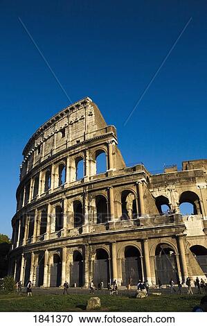 Stock Image - Tourists Watching The Colosseum; Rome, Italy. Fotosearch