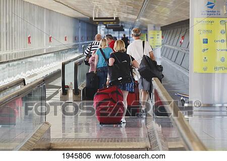 Stock Photograph - Tourists With Luggage Heading For The Departure Lounge At Malaga Airport; Malaga Province Costa Del Sol Spain. Fotosearch