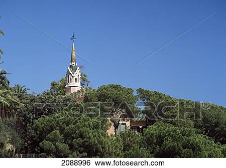 Stock Photograph - Tower From A Church Building Above The Trees Against A Blue Sky. Fotosearch