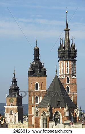 Stock Photography - Town Hall Tower, then the twin towers of St. Mary's Basilica, Old Town Square; Krakow, Poland. Fotosearch
