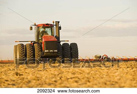 Picture - Tractor Pulling Cultivating Equipment; Lorette Manitoba Canada. Fotosearch