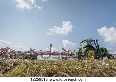Stock Image - Tractor tedding hay; Sudlersville, Maryland, United States of America. Fotosearch
