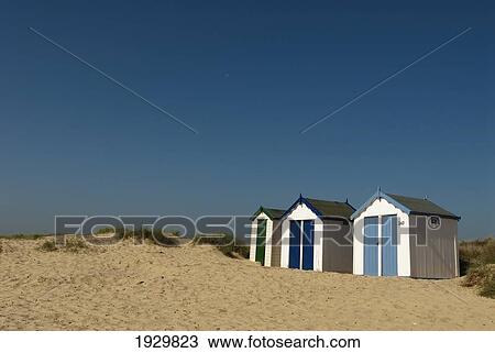 Stock Image - Traditional beach huts in the sand dunes at Southwold, Suffolk, UK. Fotosearch