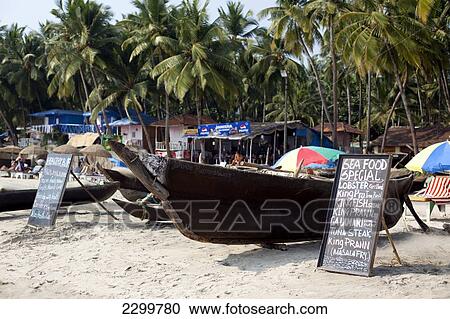 Stock Image - Traditional boats and beach front restaurants line Palolem beach, Goa, India.. Fotosearch