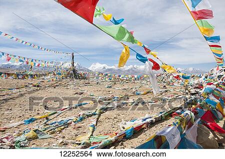 Picture - Traditional Tibetan flags on the mountain, Himalayas in the background, Tibetan Friendship Highway; Tibet, China. Fotosearch