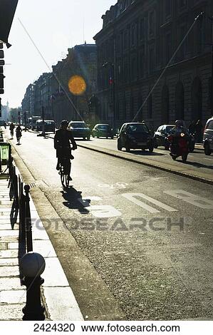 Stock Image - Traffic and cyclists on a road; Paris, France. Fotosearch