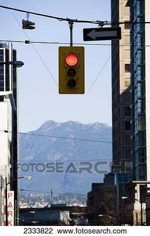 Stock Image - Traffic Light Suspended On Cable Between Buildings With View Of Mountain In Background; Vancouver, British Columbia, Canada. Fotosearch