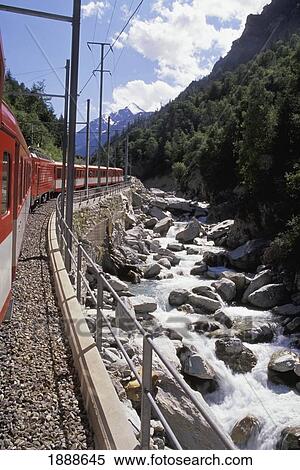 Stock Photography - Train Going Around Bend By Rocky Stream. Fotosearch