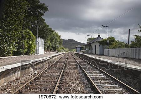 Stock Image - Train Tracks Going By A Station; Mallaig Highlands Scotland. Fotosearch