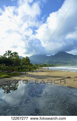 Stock Photo - Tranquil water reflects rain clouds along the coast, Hanalei Bay; Kauai, Hawaii, United States of America. Fotosearch