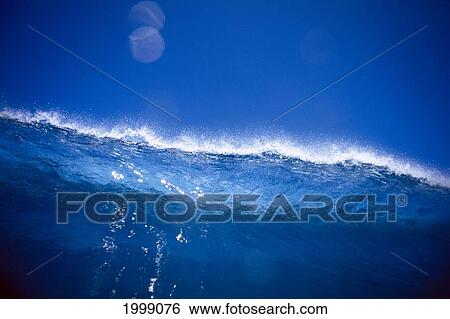 Stock Photograph - Translucent Blue Wave Against Blue Sky B1482. Fotosearch