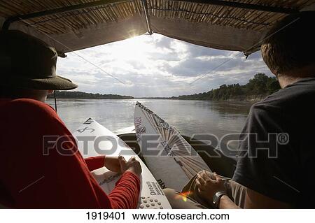 Stock Image - Travelling Surfers On River In Tanzania, East Africa.. Fotosearch