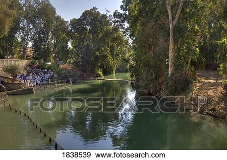 Stock Photo - Trees Reflecting In River With People Gathered On Bank. Fotosearch