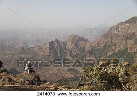 Stock Photo - Trekker resting at viewpoint, Simien Mountains National Park; Amhara region, Ethiopia. Fotosearch