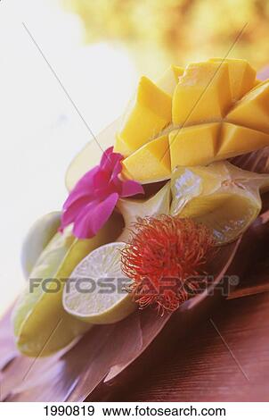 Stock Photo - Tropical Fruit With Star Fruit, Lime, Mango, Rambutan And Purple Orchid. Fotosearch