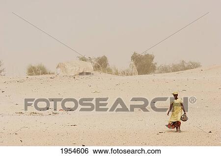 Stock Photograph - Tuareg woman in a sand storm near Timbuktu, Mali. Fotosearch