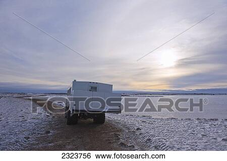 Stock Photograph - Tundra buggy on the shore of Hudson Bay at sunrise; Canada. Fotosearch