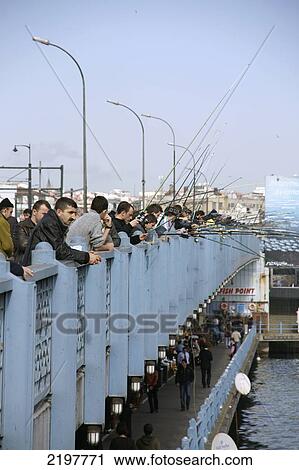 Stock Image - Turkey, Fishermen Line Sides Of Galata Bridge; Istanbul. Fotosearch