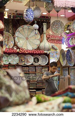 Stock Image - Turkey, Istanbul, Eminonu, Vendor At Carpet Kilim Showroom; Egyptian Bazaar. Fotosearch