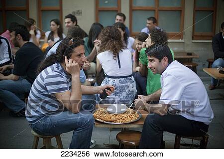Stock Photograph - Turkey, Istanbul, Nut Sellers Taking Break On Sofyali Sokak; Beyoglu District. Fotosearch