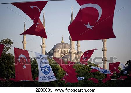 Stock Photography - Turkey, Istanbul, Turkish Flags Flapping In Breeze At Dusk Over Blue Mosque; Sultanahmet. Fotosearch