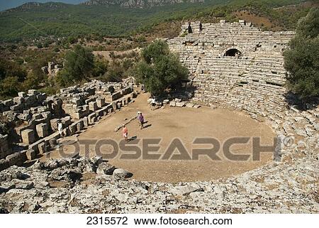 Stock Image - Turkey, Kaunos, Well preserved theatre with four people standing on stage. Fotosearch