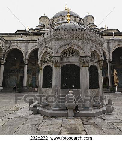 Stock Image - Turkey, Man sitting and washing his hands for ablution at Sultan Ahmed Mosque; Istanbul. Fotosearch